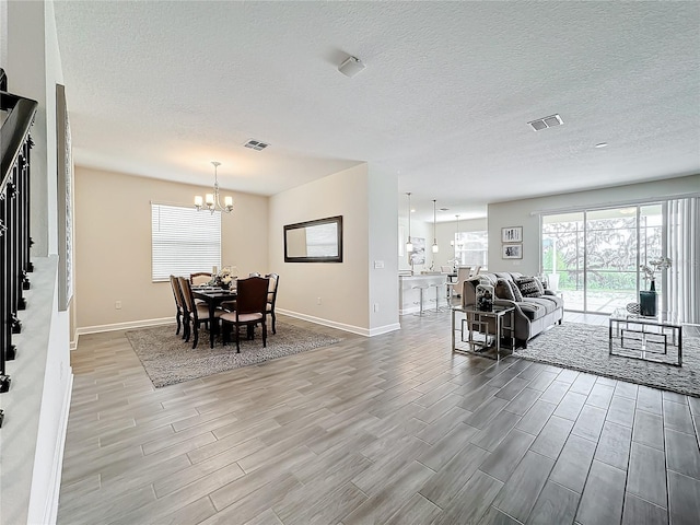 8886 Fallen Oak Dr, Davenport, FL 33896 - dining area with wood finish floors, a chandelier, and a textured ceiling