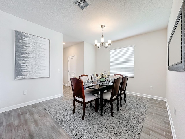 8886 Fallen Oak Dr, Davenport, FL 33896 - dining space featuring wood finished floors, a chandelier, a textured ceiling, and recessed lighting