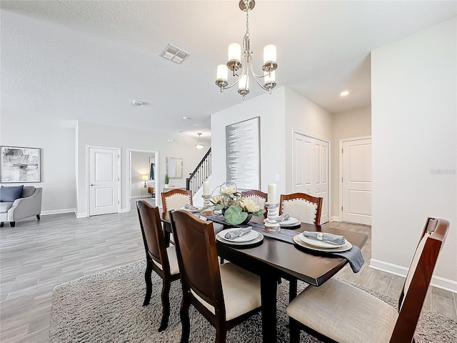 8886 Fallen Oak Dr, Davenport, FL 33896 - dining area with a chandelier, light wood-style floors, recessed lighting, and stairway