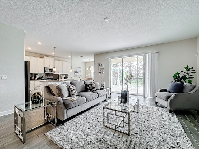 8886 Fallen Oak Dr, Davenport, FL 33896 - living area with wood finished floors, a textured ceiling, and recessed lighting