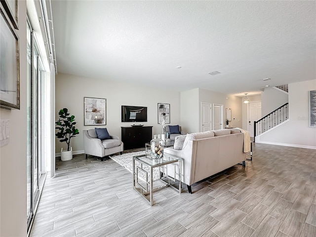 8886 Fallen Oak Dr, Davenport, FL 33896 - living area with wood tiled floors, stairs, and a textured ceiling
