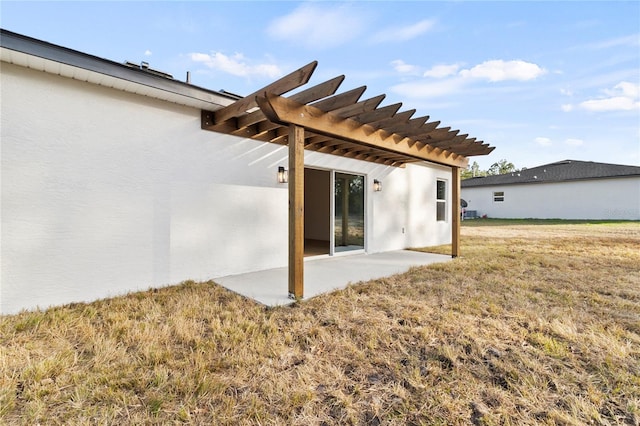 back of house with a patio area, a lawn, a pergola, and stucco siding