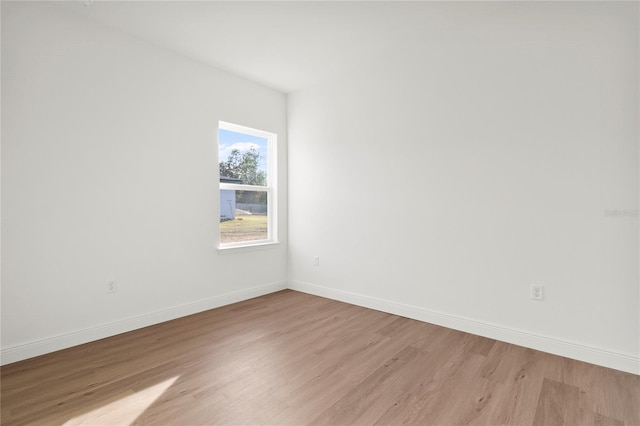 spare room with light wood finished floors and baseboards