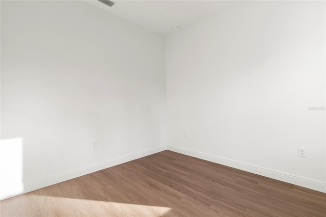 unfurnished room featuring baseboards and wood finished floors