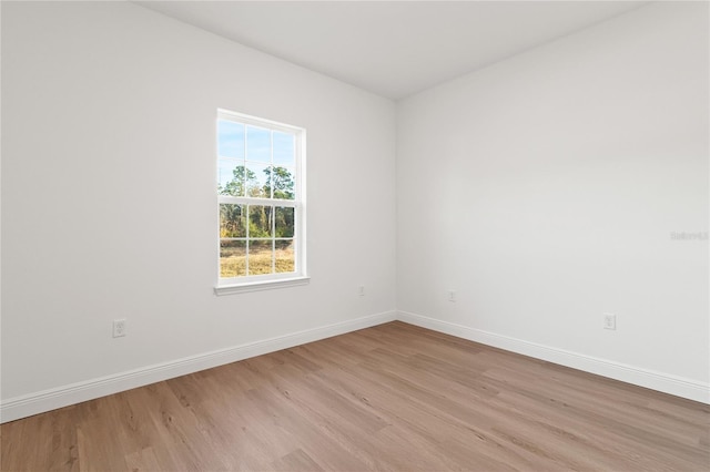 spare room with light wood finished floors and baseboards