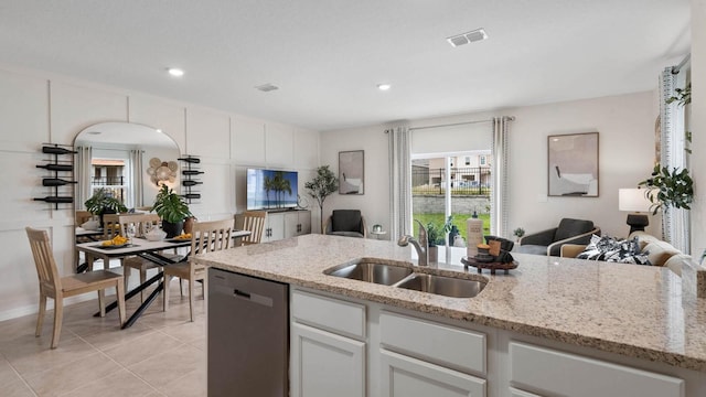 kitchen featuring dishwasher, white cabinets, sink, light stone counters, and light tile patterned flooring