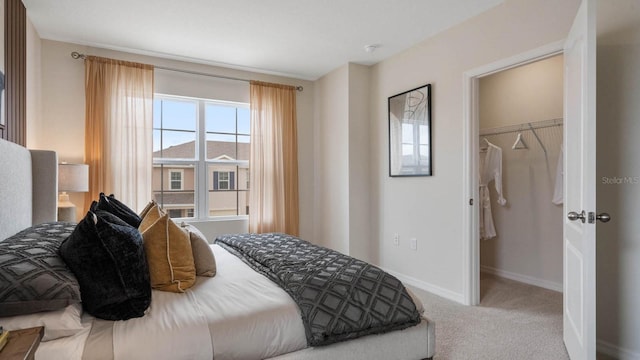 carpeted bedroom with a closet and a walk in closet