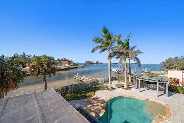 view of swimming pool with a patio area, a water view, fence, and a fenced in pool