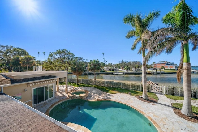 view of swimming pool featuring a water view, fence, a fenced in pool, and an in ground hot tub