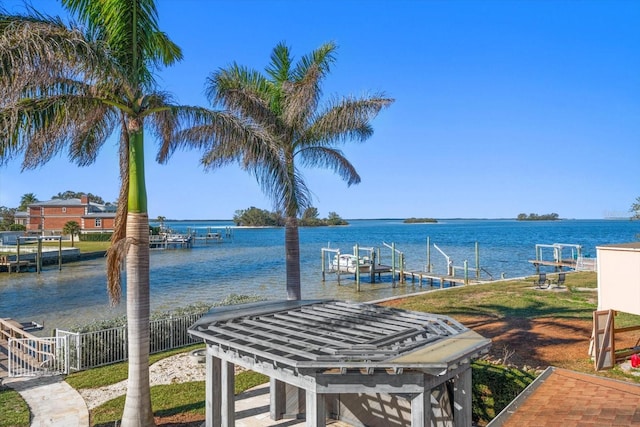 view of dock with a water view, boat lift, and fence