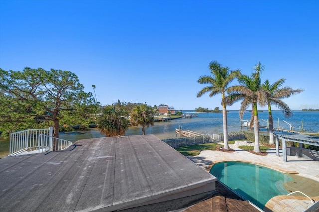 exterior space featuring a patio area, a water view, and fence