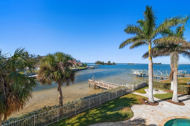 property view of water featuring boat lift, a boat dock, and fence