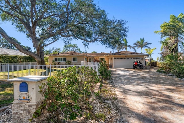 single story home with decorative driveway, fence, an attached garage, and stucco siding