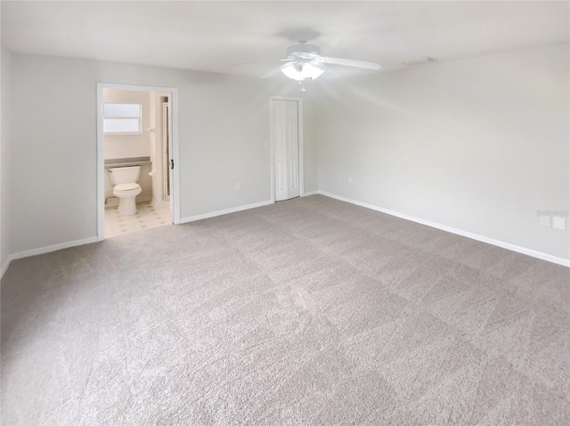 unfurnished bedroom with ensuite bath, a closet, ceiling fan, and carpet