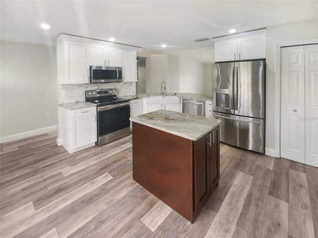 kitchen with sink, decorative backsplash, light stone counters, kitchen peninsula, and stainless steel appliances