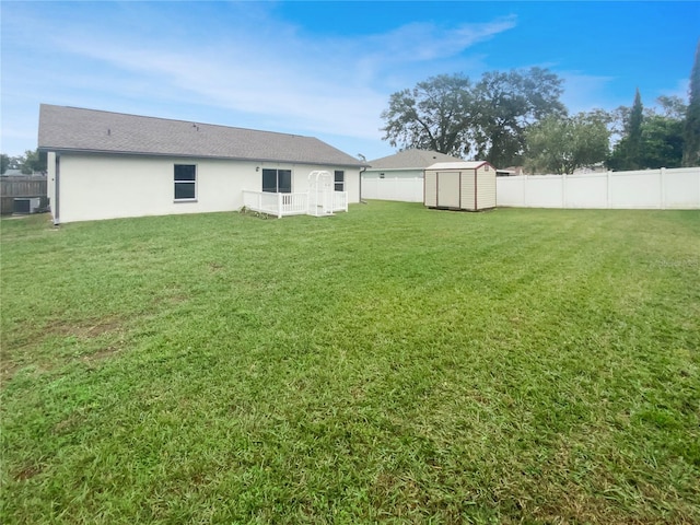 exterior space with a lawn, central air condition unit, and a storage unit