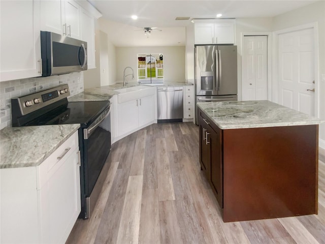 kitchen with white cabinetry, appliances with stainless steel finishes, kitchen peninsula, and sink