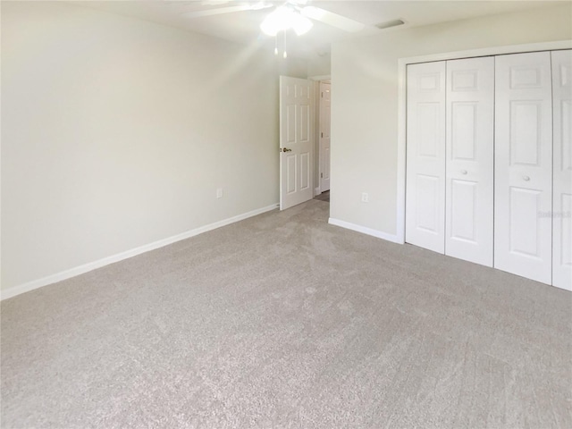 unfurnished bedroom featuring carpet, ceiling fan, and a closet