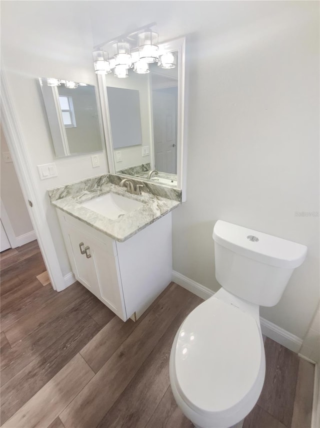 bathroom featuring vanity, toilet, and hardwood / wood-style floors