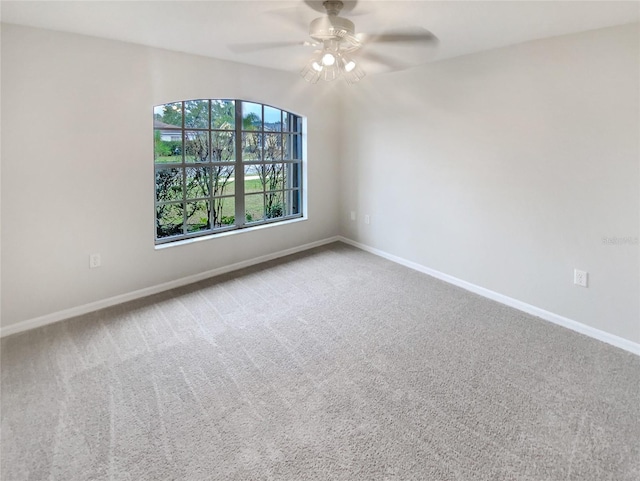 empty room featuring ceiling fan and carpet