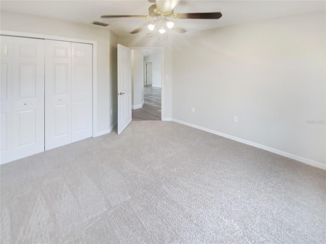 unfurnished bedroom with ceiling fan, carpet, and a closet