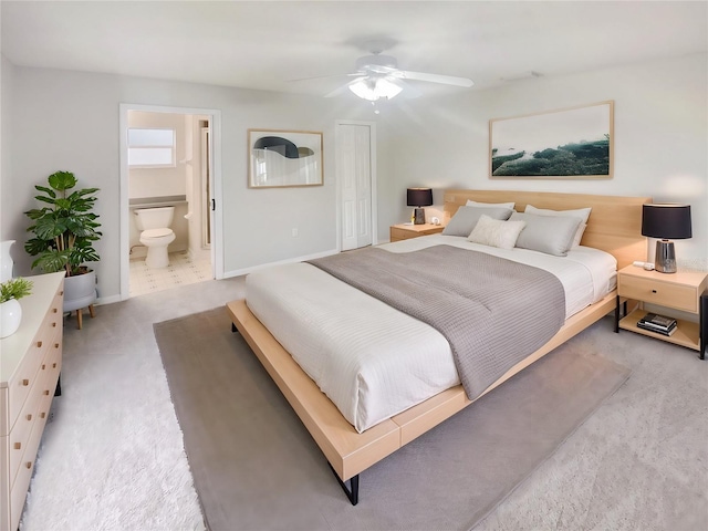 bedroom with ensuite bathroom, carpet, and ceiling fan