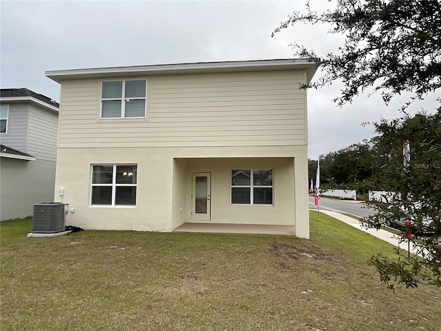 rear view of house with a lawn, central AC, and a patio