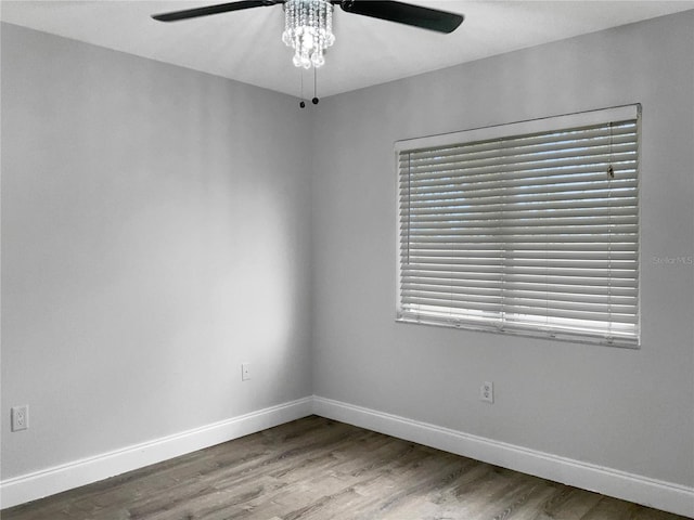 spare room featuring wood-type flooring, a healthy amount of sunlight, and ceiling fan