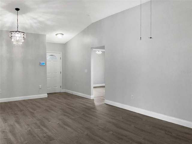 spare room featuring vaulted ceiling, a chandelier, and dark hardwood / wood-style floors