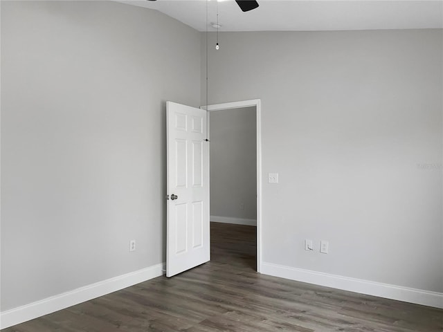 empty room with ceiling fan, dark wood-type flooring, and vaulted ceiling