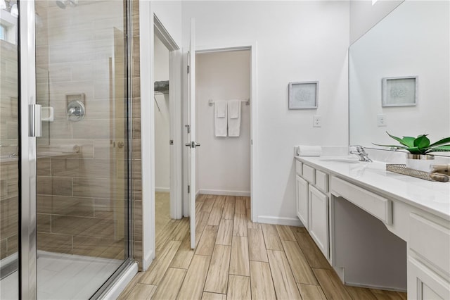 bathroom featuring walk in shower and vanity