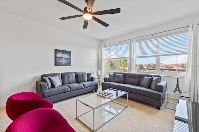 living room with light carpet, ceiling fan, and a textured ceiling