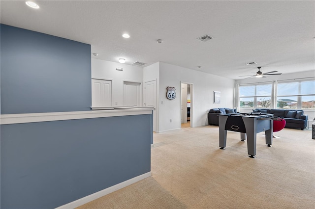 game room with light carpet, a textured ceiling, and ceiling fan