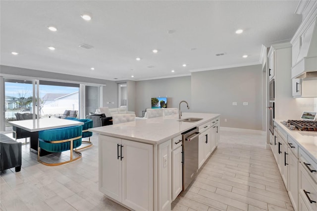 kitchen featuring sink, stainless steel appliances, an island with sink, white cabinets, and custom range hood