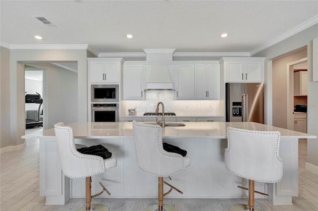 kitchen with white cabinetry, stainless steel appliances, a large island, and a kitchen breakfast bar