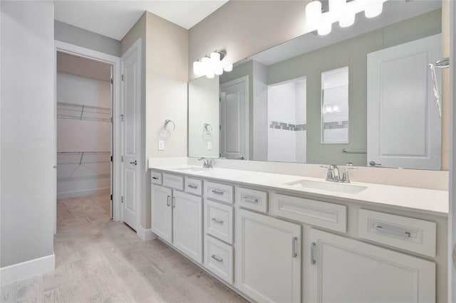 bathroom with hardwood / wood-style flooring, vanity, and a shower