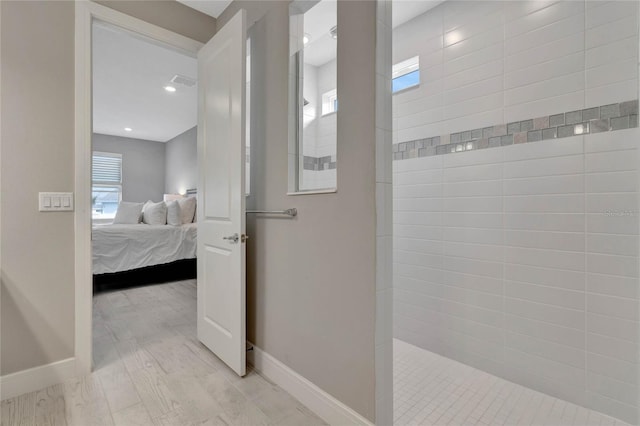 bathroom featuring a tile shower and hardwood / wood-style floors