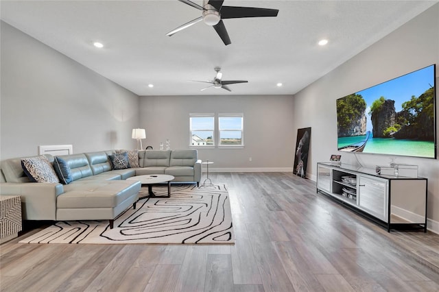 living room with light hardwood / wood-style flooring and ceiling fan