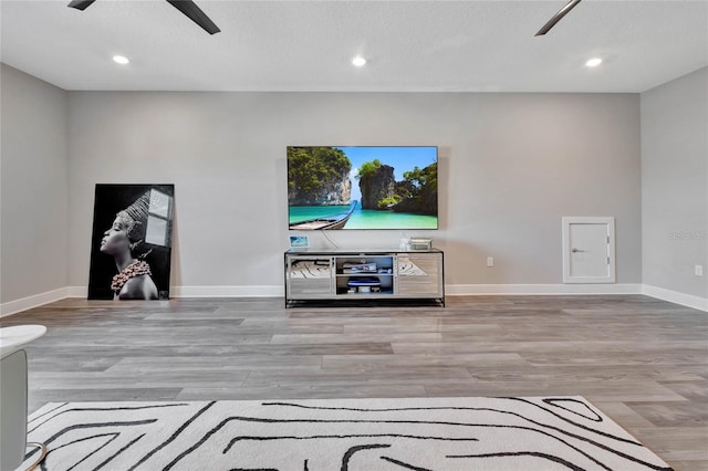 living room with ceiling fan and light wood-type flooring