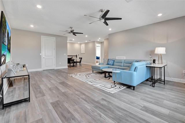 living room featuring ceiling fan and light hardwood / wood-style flooring