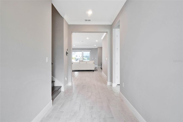 corridor with crown molding and light hardwood / wood-style flooring