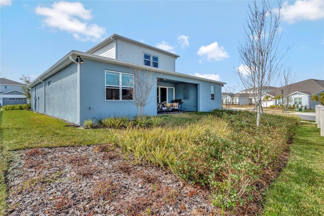 rear view of property featuring a lawn