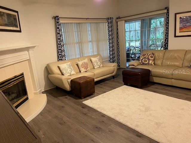 living room featuring dark hardwood / wood-style flooring and a tiled fireplace