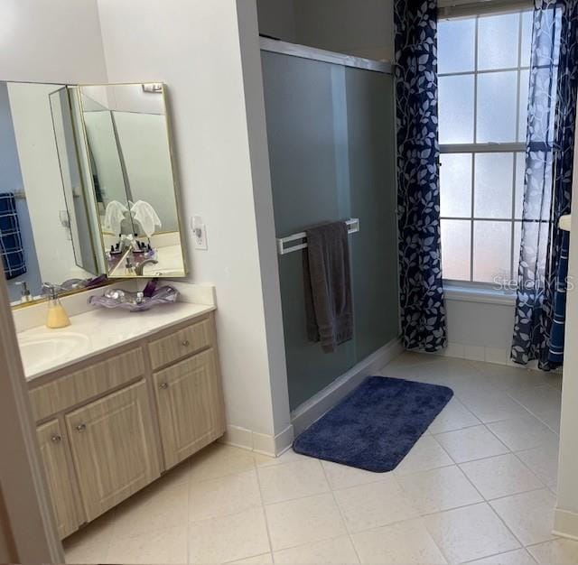 bathroom with a shower, tile patterned floors, and vanity