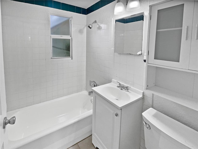 full bathroom featuring tiled shower / bath combo, vanity, tile walls, and toilet