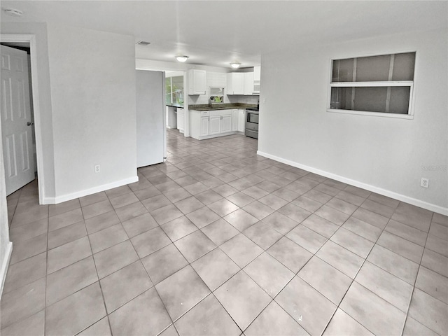 unfurnished living room with sink and light tile patterned flooring