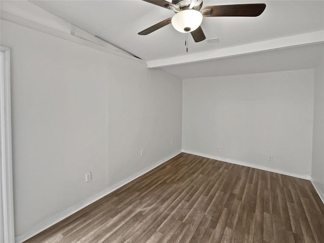 spare room featuring dark wood-type flooring, ceiling fan, and beam ceiling