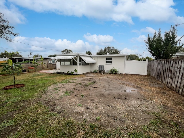 back of house featuring cooling unit and a lawn