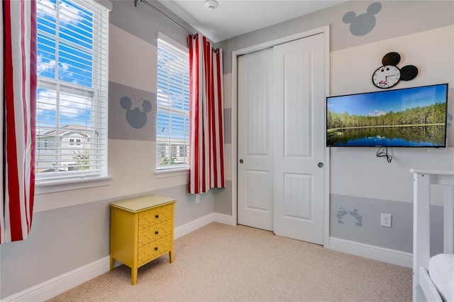 bedroom with light colored carpet and a closet