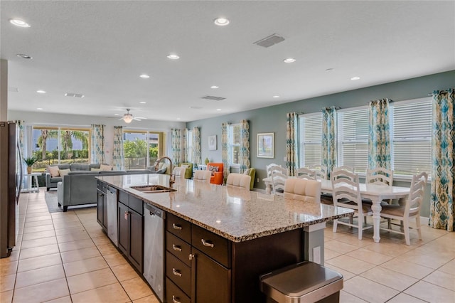 kitchen featuring stainless steel appliances, a kitchen bar, sink, and a large island with sink